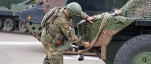  Ein Bundeswehrsoldat überprüft die Tarnung und Ausrüstung eines Spähpanzers Fennek.