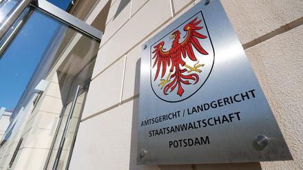 Das Metallschild neben dem Eingang zum Justizzentrum mit dem roten Adler als Landeswappen und dem Verweis auf Amtsgericht, Landgericht und Staatsanwaltschaft. 
