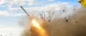 Artilleristen feuern einen RM-70 Mehrfachraketenwerfer nahe der Front ab.