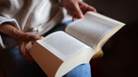 ILLUSTRATION - Eine Frau liest ein Buch.