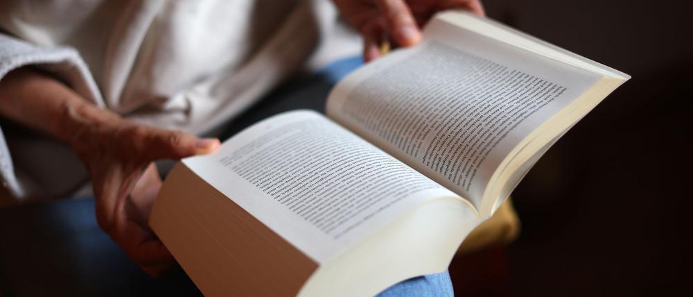 ILLUSTRATION - Eine Frau liest ein Buch.