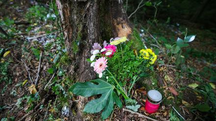 Blumen und eine Kerze stehen an der Unfallstelle an einem Baum. Bei einem schweren Autounfall sind am 16.08.2025 zwei Jugendliche und zwei junge Erwachsene ums Leben gekommen. 