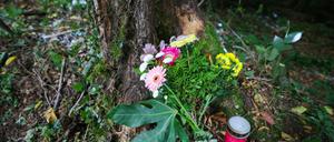 Blumen und eine Kerze stehen an der Unfallstelle an einem Baum. Bei einem schweren Autounfall sind am 16.08.2025 zwei Jugendliche und zwei junge Erwachsene ums Leben gekommen. 