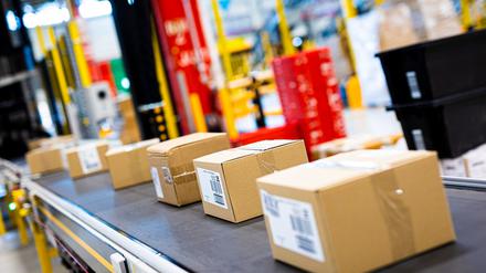 Pakete fahren im Logistikzentrum des Onlineversandhändlers Amazon über ein Laufband.