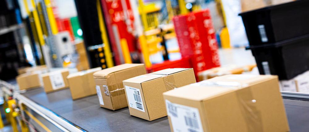 Pakete fahren im Logistikzentrum des Onlineversandhändlers Amazon über ein Laufband.