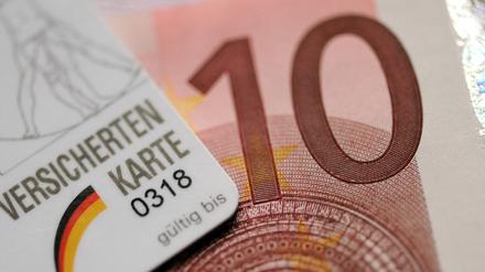 Ein Zehn-Euro-Schein liegt am 05.11.2012 unter einer Versichertenkarte. 