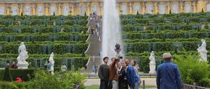 Besucher machen an der großen Treppe vor Schloss Sanssouci ein Selfie.