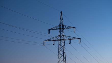 Baden-Württemberg, Rottweil: Ein Strommast ist bei Sonnenaufgang als Silhouette zu sehen.