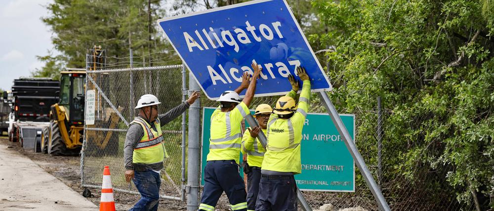 Arbeiter errichten Anfang Juli ein Schild, das auf die Haftanstalt hinweist.