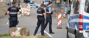 22.08.2025, Saarland, Völklingen: Polizeibeamte untersuchen das Umfeld eines Tatorts.