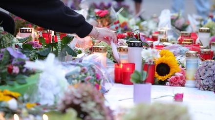 Nach der Messerattacke auf dem Solinger Stadtfest legen Menschen in der Nähe des Tatortes Blumen nieder und zünden Kerzen zum Gedenken der Opfer an.
