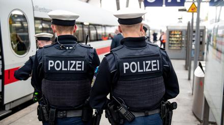Bundespolizisten stehen vor der Abfahrt eines ICE an einem Gleis im Kieler Hauptbahnhof.
