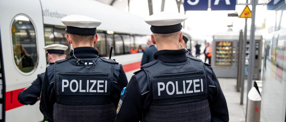 Bundespolizisten stehen vor der Abfahrt eines ICE an einem Gleis im Kieler Hauptbahnhof.