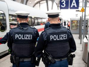 Bundespolizisten stehen vor der Abfahrt eines ICE an einem Gleis im Kieler Hauptbahnhof.