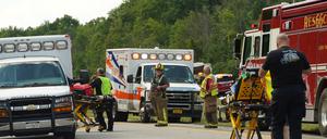 Rettungskräfte arbeiten an der Unfallstelle eines Reisebusses, der sich auf dem New York State Thruway in der Nähe von Pembroke, N.Y., überschlagen hat.