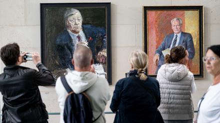 Menschen stehen am Tag der offenen Tür der neuen Bundesregierung im Kanzleramt vor den Porträts der ehemaligen Kanzlern Schmidt (l) und Brandt.
