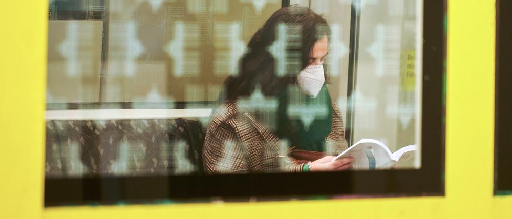 Eine Frau sitzt mit FFP2-Maske in einer U-Bahn am Hauptbahnhof.