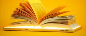 Ein aufgeschlagenes Buch liegt auf einem iPad.