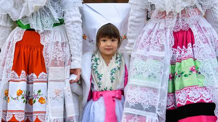 Henriette steht in original wendischer Festtagstracht zwischen ihrer Schwester Alice (l) und ihrer Mutter Tina beim traditionellen Zapust, der Jugend-Fastnacht in Burg (Spreewald). 