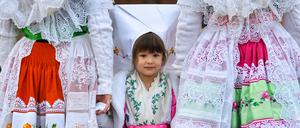 Henriette steht in original wendischer Festtagstracht zwischen ihrer Schwester Alice (l) und ihrer Mutter Tina beim traditionellen Zapust, der Jugend-Fastnacht in Burg (Spreewald). 