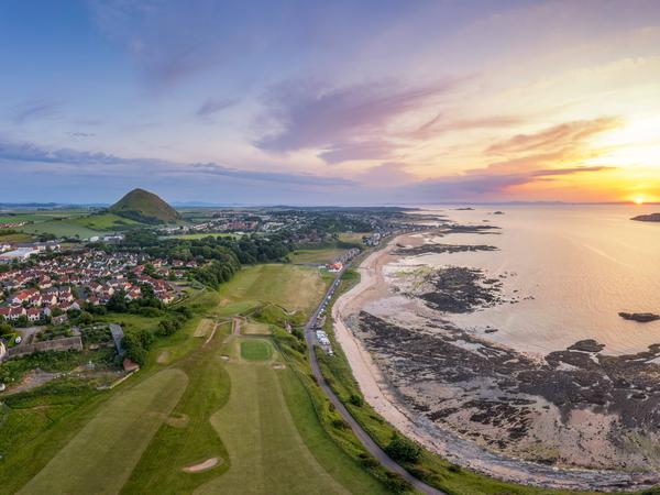 UK, Scotland, North Berwick, Aerial view of beach in front of coastal town at sunset, North Berwick Scotland United Kingdom SMAF02672