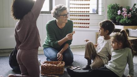 Eine Senioren-Lehrerin spielt in einem schwedischen Kindergarten mit Kindern im Vorschulalter. 