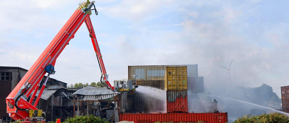 Hamburg: Einsatzkräfte der Feuerwehr löschen einen Brand in einem Industriegebiet im Hamburger Hafen, in dem ein Großbrand ausgebrochen war. In der Nacht zu Mittwoch ist es erneut zu Explosionen gekommen. Zwei Container gingen in Flammen auf und mussten aus sicherer Entfernung mit Wasserwerfern gelöscht werden, wie ein Sprecher der Hamburger Feuerwehr mitteilte.