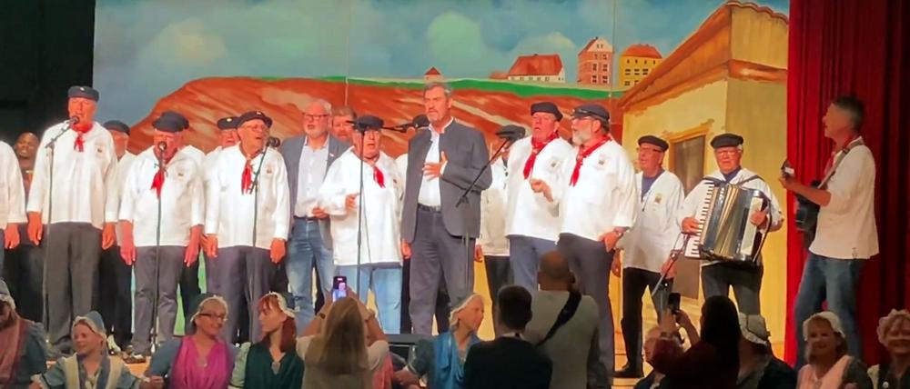 Helgoland: Bayerns Ministerpräsident Markus Söder (3.v.r. CSU) steht bei seinem Besuch auf Helgoland gemeinsam mit einem Shantychor auf einer Bühne.