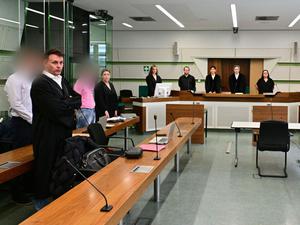 Zwei der drei Angeklagten (l und 3.v.l.) stehen mit ihren Anwälten vor Prozessbeginn um die Vergewaltigung eines Bundeswehrsoldaten in einem Saal am Kriminalgericht Moabit. Angeklagt sind insgesamt drei damalige Soldaten (Archivbild)
