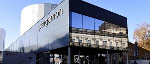 Das temporäre Ausstellungsgebäude des Pergamonmuseums in Berlin mit einer verspiegelten Glasfassade gestützt auf Säulen und der Aufschrift „Pergamon“. 