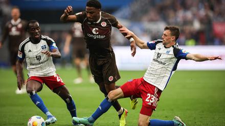 Voll dabei: St. Paulis Oladapo Afolayan (M) kämpft mit Hamburgs Jean-Luc Dompe (l) und Hamburgs Jonas Meffert um den Ball. (Archiv)
