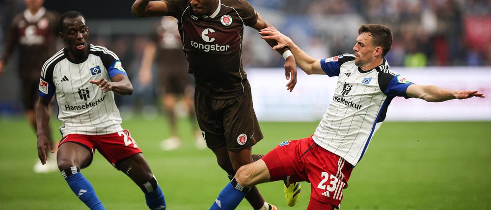 Voll dabei: St. Paulis Oladapo Afolayan (M) kämpft mit Hamburgs Jean-Luc Dompe (l) und Hamburgs Jonas Meffert um den Ball. (Archiv)