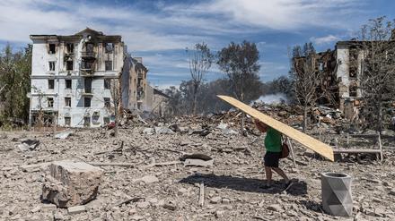 Ein Zivilist trägt eine Holzplatte, um die Fenster seines zerstörten Hauses abzudecken, nachdem Russland am 1. August 2025 ein Gebäude im Zentrum von Kramatorsk, Ukraine, bombardiert hat (Symbolbild).