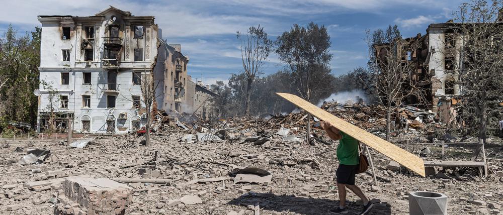 Ein Zivilist trägt eine Holzplatte, um die Fenster seines zerstörten Hauses abzudecken, nachdem Russland am 1. August 2025 ein Gebäude im Zentrum von Kramatorsk, Ukraine, bombardiert hat (Symbolbild).