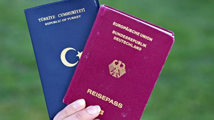 Eine Studentin zeigt einen türkischen Pass (l) und einen deutschen Reisepass. 