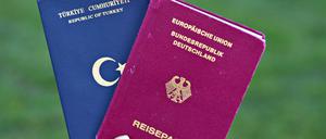 Eine Studentin zeigt einen türkischen Pass (l) und einen deutschen Reisepass. 