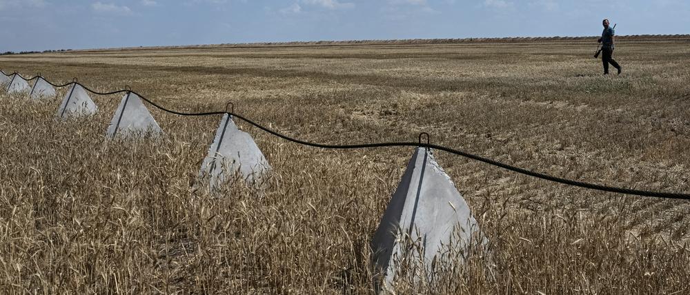 Ein bewaffneter Zivilist kontrolliert ein Gebiet nahe der Frontlinie bei Saporischschja, in dem russische Kampfdrohnen herumfliegen. 