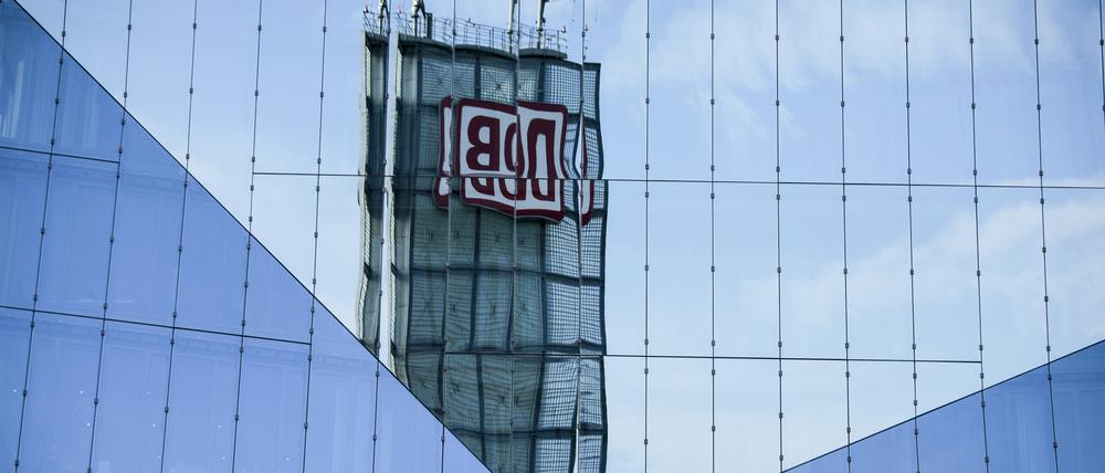 Das Logo der Deutschen Bahn spiegelt sich in der Fassade eines Hotels am Berliner Hauptbahnhof.