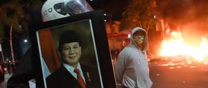 Schwere Proteste in Indonesien: Vermummte Demonstranten mit einem Bild von Präsident Prabowo Subianto.