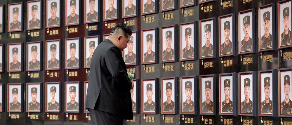 Der nordkoreanische Staatschef Kim Jong Un steht vor einer Portraitwand gefallener Soldaten.