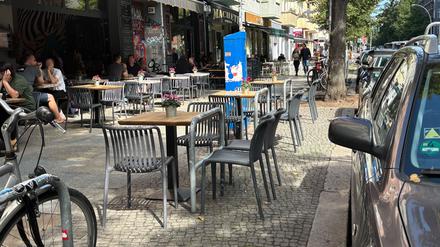 Ein Restaurant in Friedrichshain stellt Tische und Stühle an Fahrradbügel.