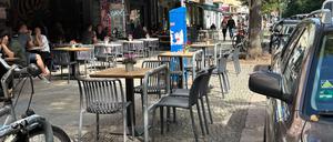 Ein Restaurant in Friedrichshain stellt Tische und Stühle an Fahrradbügel.