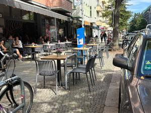 Ein Restaurant in Friedrichshain stellt Tische und Stühle an Fahrradbügel.