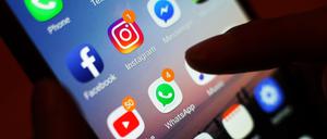 Ein Smartphone-Display mit Symbolen von Social-Media-Apps, darunter Facebook, Instagram, YouTube und WhatsApp. 