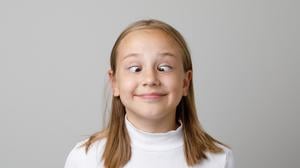 Ein Mädchen schielt absichtlich und hat Spaß dabei.