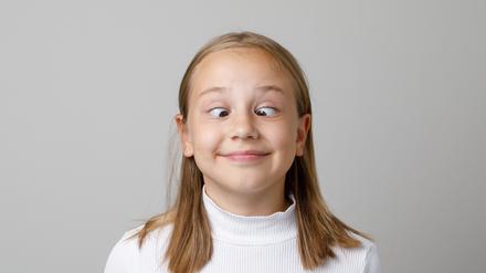 Ein Mädchen schielt absichtlich und hat Spaß dabei.