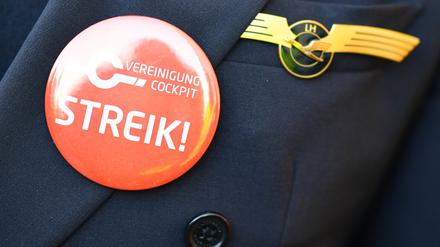 Ein Lufthansa-Pilot trägt bei einer Kundgebung der Pilotengewerkschaft Vereinigung Cockpit einen Button mit der Aufschrift „Streik“ auf seiner Uniform. 
