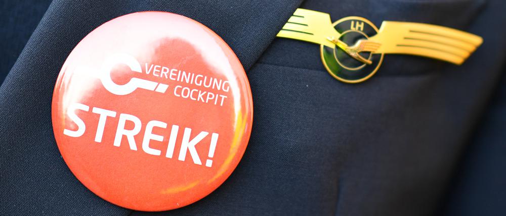 Ein Lufthansa-Pilot trägt bei einer Kundgebung der Pilotengewerkschaft Vereinigung Cockpit einen Button mit der Aufschrift „Streik“ auf seiner Uniform.