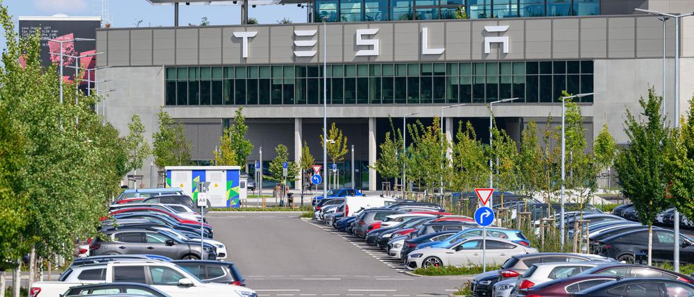Autos parken vor dem Werk der Tesla-Gigafactory Berlin-Brandenburg in Grünheide.