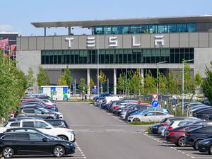 Autos parken vor dem Werk der Tesla-Gigafactory Berlin-Brandenburg  in Grünheide.